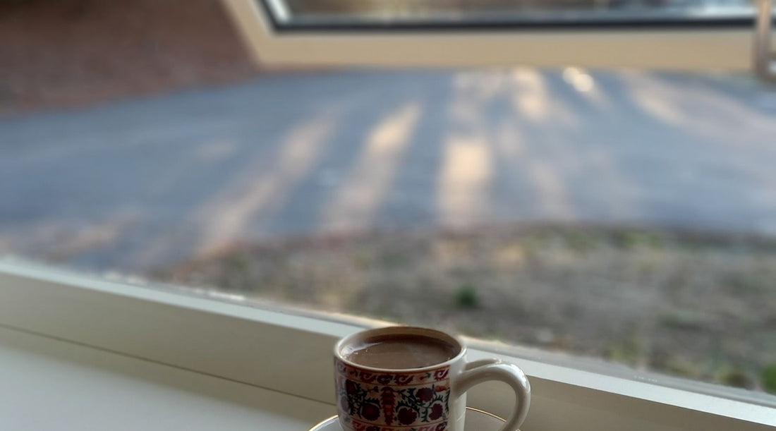 Coffee cup on a sunny window sill overlooking a forest, a calm start to a daily CBD routine