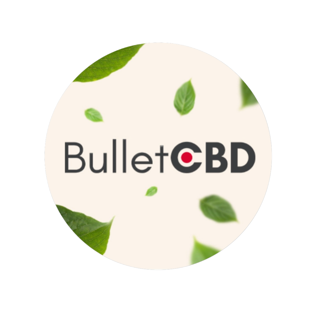 A circular product label or sticker featuring the brand name 'BulletCBD' in dark gray text with a small red dot in the 'O', surrounded by scattered green leaves on a warm off-white background.