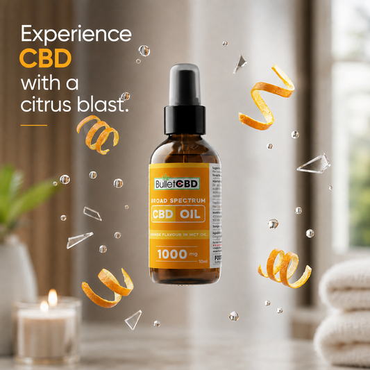 A bottle of Bullet CBD Broad Spectrum CBD Oil in a citrus blast flavor, floating in a softly blurred bathroom setting with floating orange peel curls, clear bubbles, and a lit candle. Text on the left reads 'Experience CBD with a citrus blast.